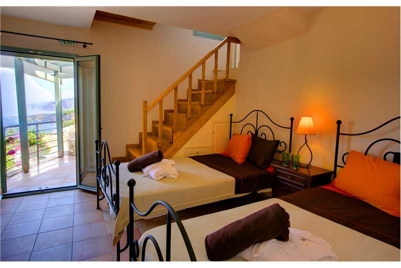 Villa Prikonas twin bedroom with stairs leading up to the kitchen